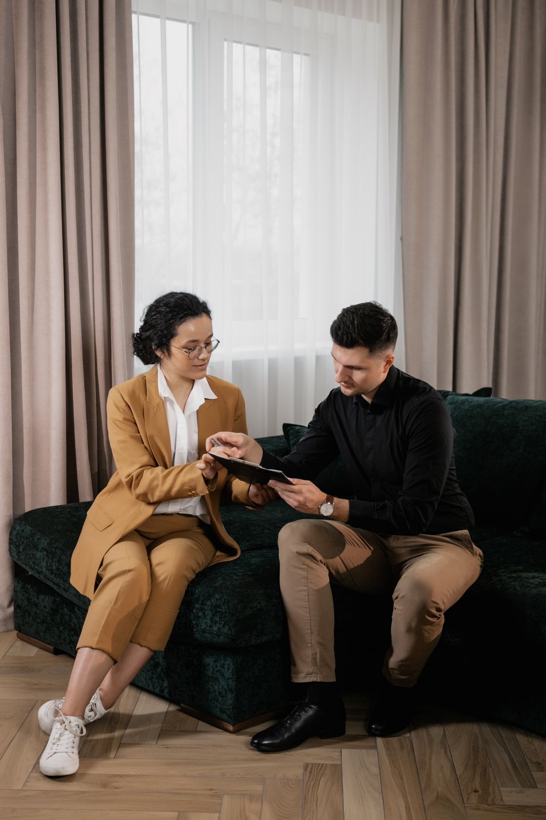 A realtor showing a printed document to a client across a table — the manual handoff automation replaces